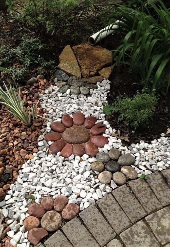 Large Flowers on Colorful Rock Bed #riverrocklandscaping #decorhomeideas